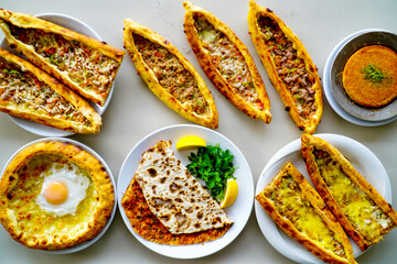 Traditional Turkish cuisine. Pizza, pita, pidesi, sucuk, hummus, kebab. Many dishes on the table. Serving dishes in restaurant. Background image. Top view, flat lay