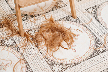 cut hair falls to the floor. waste from cutting hair. cleaning in hairdressing salons.