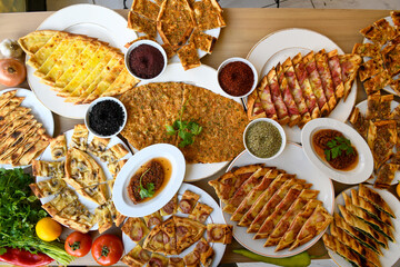 Traditional Turkish cuisine. Pizza, pita, pidesi, sucuk, hummus, kebab. Many dishes on the table. Serving dishes in restaurant. Background image. Top view, flat lay