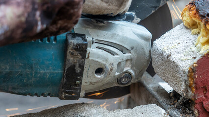 Close-up view of a worker working with angle grinder. Electric wheel grinding on steel structure. Sparks.