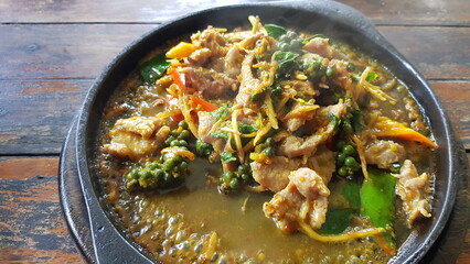 Spicy stir-fried beef served in a metal pan over high heat.