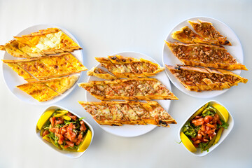 Traditional Turkish cuisine. Pizza, pita, pidesi, sucuk, hummus, kebab. Many dishes on the table. Serving dishes in restaurant. Background image. Top view, flat lay