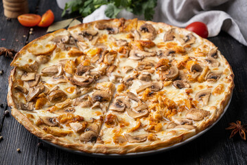Mushroom pizza on black wooden background.