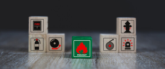 Cube wooden block stack with fire icon and door exit sing or fire escape with prevent icon and fire...