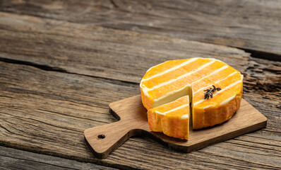 cream Round brie or camambert cheese on a wooden board. Rougette cheese on a wooden background,...