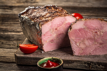 Traditional French Pate en croute with goose meat and liver as closeup on a wooden board. banner...