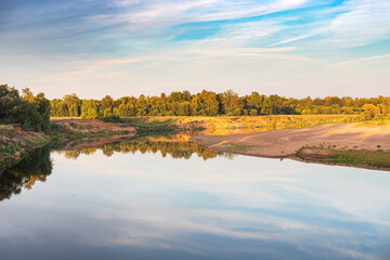 Calm river with reflections of majestic sunset sky