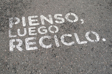 I think, then I recycle. Environmentalist message painted on the street asphalt