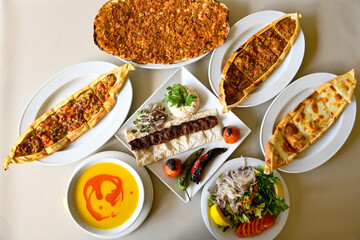 Delicious meat kebab with fresh vegetable salad served with variety of Turkish dishes and appetizers. Top view of assorted Turkish food and meze, tasty and healthy Mediterranean cuisine.