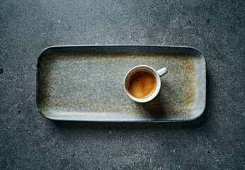 Cup of espresso coffee on rustic ceramic plate