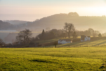 Obraz premium Winter in the Forest of Dean - Early morning light on cottages nestling below Littledean Hill, Littledean, Gloucestershire, England UK