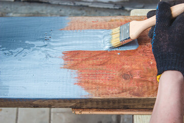 hand holds a brush, apply varnish paint on the board. board painting.
