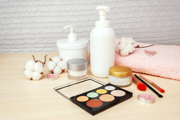 Face makeup products, cream, lotion for face makeup, face contouring palette, makeup brushes, cotton flowers. Copy space.