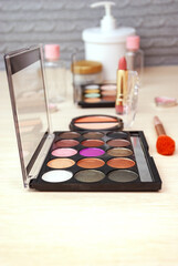 Cosmetics for professional makeup at home. Palettes of shadows, lipstick, cream and more. Selective focus.