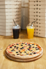 pizza on a wooden table with lemonade 