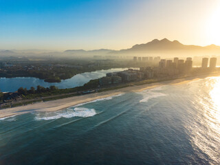 Aerial view of Reserva beach, Marapendi lagoon and car traffic on Lucio Costa avenue. Barra da Tijuca and Recreio, in Rio de Janeiro, Brazil. Sunrise. Sunny day. Drone photo. Praia da Reserva