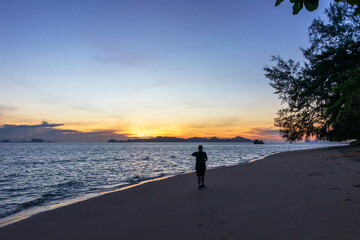 Silhouette of a women running along the beach of the sea during an amazing sunrise. Female going for a early morning run.