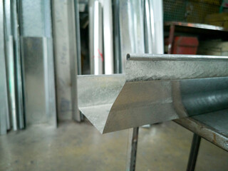 Galvanized gutters in right position, Galvanized steel gutters is put on the stainless table, photo is Depth of Field style
