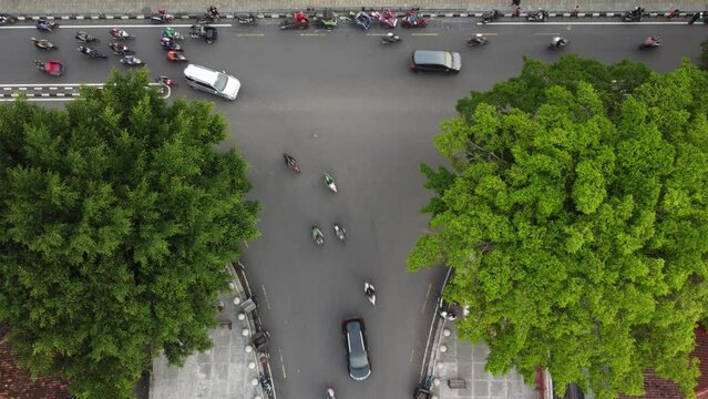 The traffic of vehicles at a crossroads in the city of yogyakarta. Top aerial drone view.