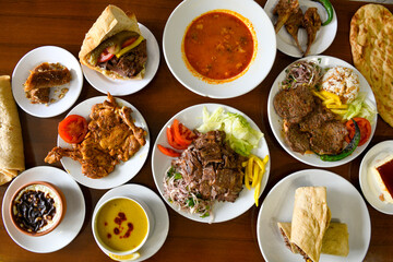 Delicious meat kebab with fresh vegetable salad served with variety of Turkish dishes and appetizers. Top view of assorted Turkish food and meze, tasty and healthy Mediterranean cuisine.