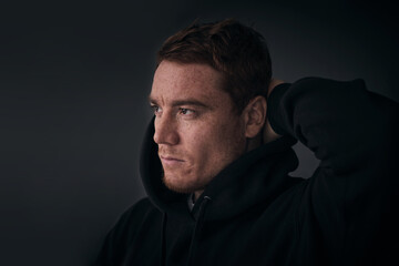 portrait of attractive middle aged red hair man in a black hoodie. strong man portrait. freckles...