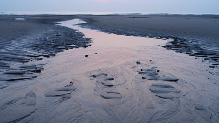 Stream of water on the beach on the French opal coast pastel colors Copy space Horizon structure