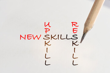 New skills, reskill and upskill written on white paper with pencil. Future of work concept and success idea