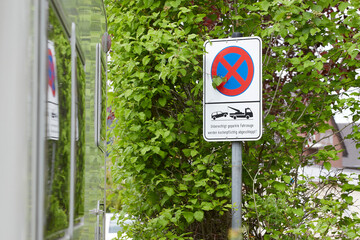 german sign, not allowed to part and that parking cars will be towed away. reflection of the sign...