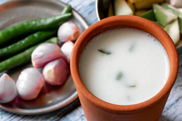 Fermented rice mixed with curd along with side dish of onion and green chili. Traditional South Indian breakfast of overnight soaked rice and plain yogurt mixed.