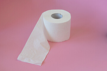 Rolls of white toilet paper on pink background