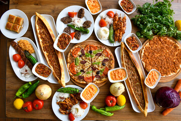 Traditional Turkish cuisine. Pizza, pita, pidesi, sucuk, hummus, kebab. Many dishes on the table. Serving dishes in restaurant. Background image. Top view, flat lay