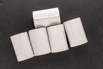 Several rolls of paper tape for a cash register on a slate stone, macro, top view.