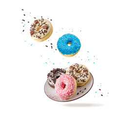 Colorful glazed donuts with mixed sprinkles and crumbs flying isolated on white background.