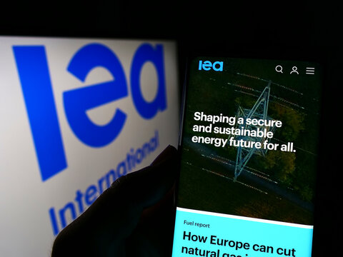 Stuttgart, Germany - 03-05-2022: Person holding cellphone with website of organisation International Energy Agency (IEA) on screen with logo. Focus on center of phone display.