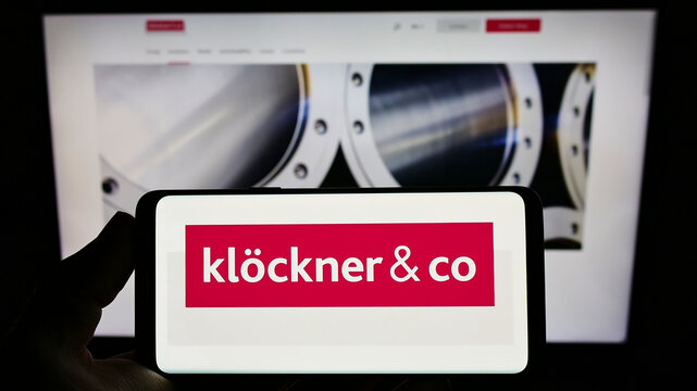 Stuttgart, Germany - 03-06-2022: Person holding smartphone with logo of German metal company Kl&ouml;ckner Co SE on screen in front of website. Focus on phone display.