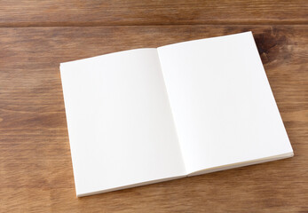 斜めアングルから見たデスクの上の空白の白い見開きノート