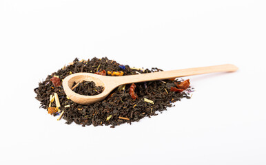 Black tea in a pile and in a wooden spoon isolated on a white background. Dry tea leaves in a pile...