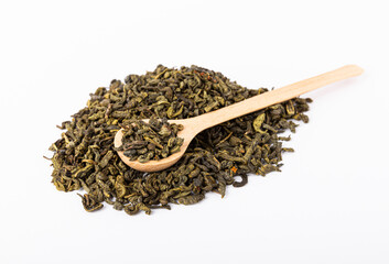 A mound of green tea with a wooden spoon isolated on a white background. Dry tea leaves in a pile on a white background.