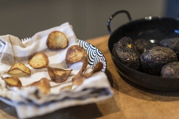 Preparing dinner. Potatoes in ashes, cream, truffles, chives, plate. Table, close-up, dining, background, lighting, people. Beautiful surroundings, adventure restaurant.