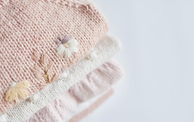 Stack of knitted clothes. Baby clothes. Needlework, hobby, knitting, handwork.