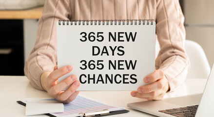 365 NEW DAY, 365 NEW CHANCE written in a notebook in hands. Concept business and finance