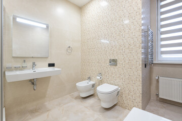 Fototapeta na wymiar large bathroom with bath and shower in beige tiles, modern bathroom