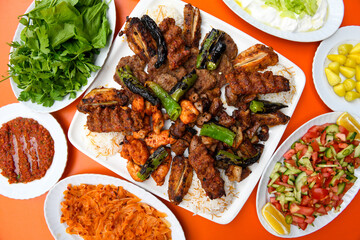 Delicious meat kebab with fresh vegetable salad served with variety of Turkish dishes and appetizers. Top view of assorted Turkish food and meze, tasty and healthy Mediterranean cuisine.