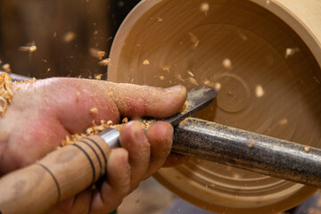 Closeup of carpenter turning wood on a lathe
