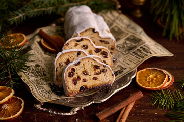Christmas stollen on wooden background. Traditional christmas german dessert cut into pieces. Cake with nuts, raisins with marzipan and dried fruit on cutting board. baking for xmas