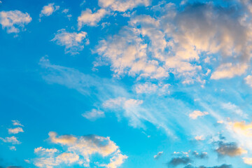 Fototapeta na wymiar Blue sky background with white and pink cumulus clouds. Evening or morning time. Heaven concept. Dreams and imagination. Tranquil space. Natural landscape