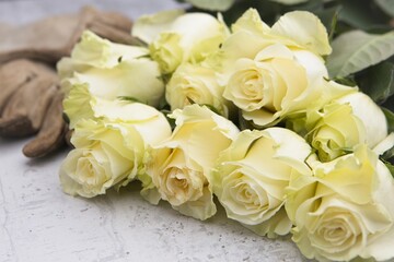 Yellow roses stacked up on table.
