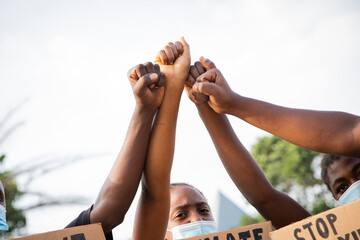 Close-up of the raised fists of a group of African guys protesting