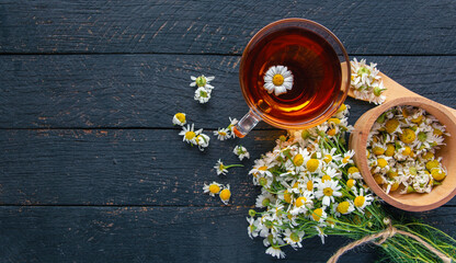 cup of herbal chamomile tea and daisy tea bags and fresh flower