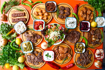 Delicious meat kebab with fresh vegetable salad served with variety of Turkish dishes and appetizers. Top view of assorted Turkish food and meze, tasty and healthy Mediterranean cuisine.